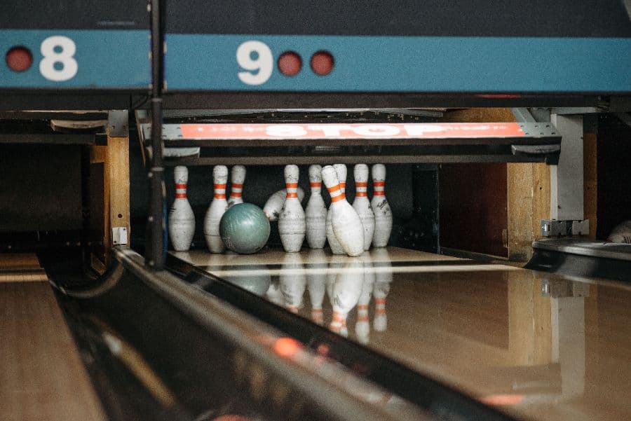 Bowling ball striking pins at the end of a lane