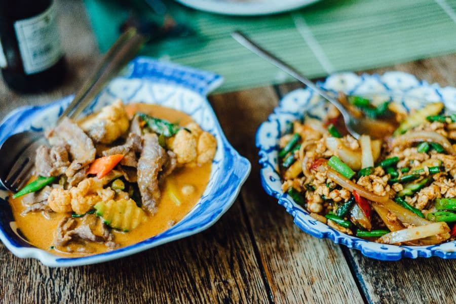 Two curry dishes on patterned plates at Tera Kitchen